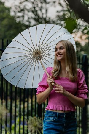 a very gorgeous senior portrait of a girl holding a parasol and gazing into the sunset