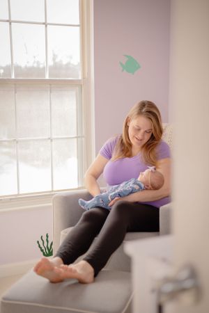 a mother holds her sleeping baby in a beautiful candid captured moment