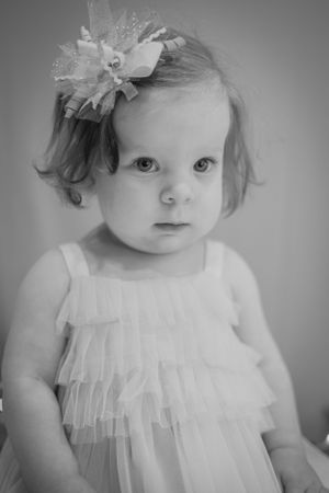 an adorable little girl poses for a first birthday portrait