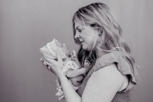a beautiful portrait of a mother gazing at her sleeping baby