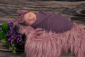 a sleeping baby sleeps on a purple fury blanket