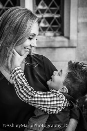 a breathtaking picture of a boy holding his mothers face while they smile at each other