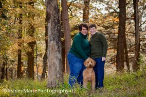 Posed with their dog, a mother and son are bathed in creamy sunlight