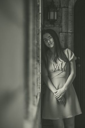 creamy colors, classic black and white senior portrait in a stone hallway