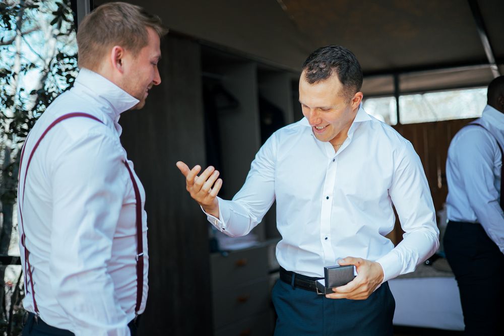 Two people in dress shirts engaging in conversation while looking at a mobile device.