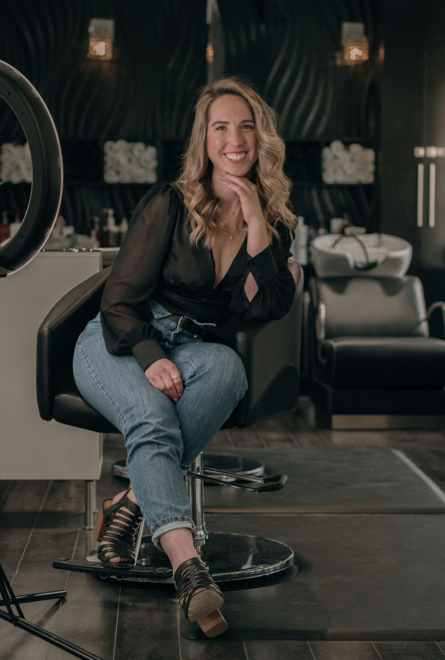 Modern salon workspace with hardwood floors and stylish black furnishings.