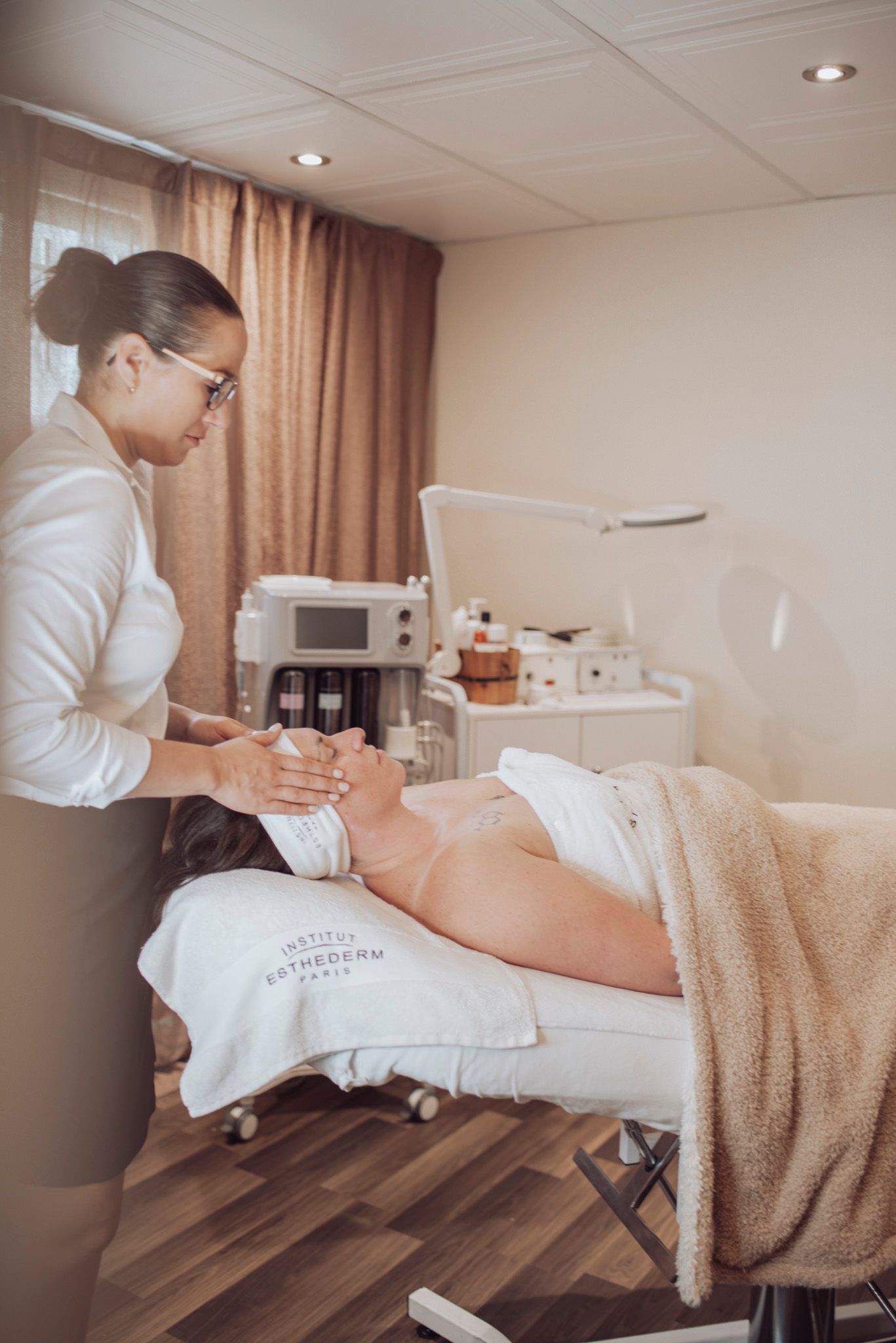 Therapeutic massage treatment being performed in a professional spa setting with white decor.