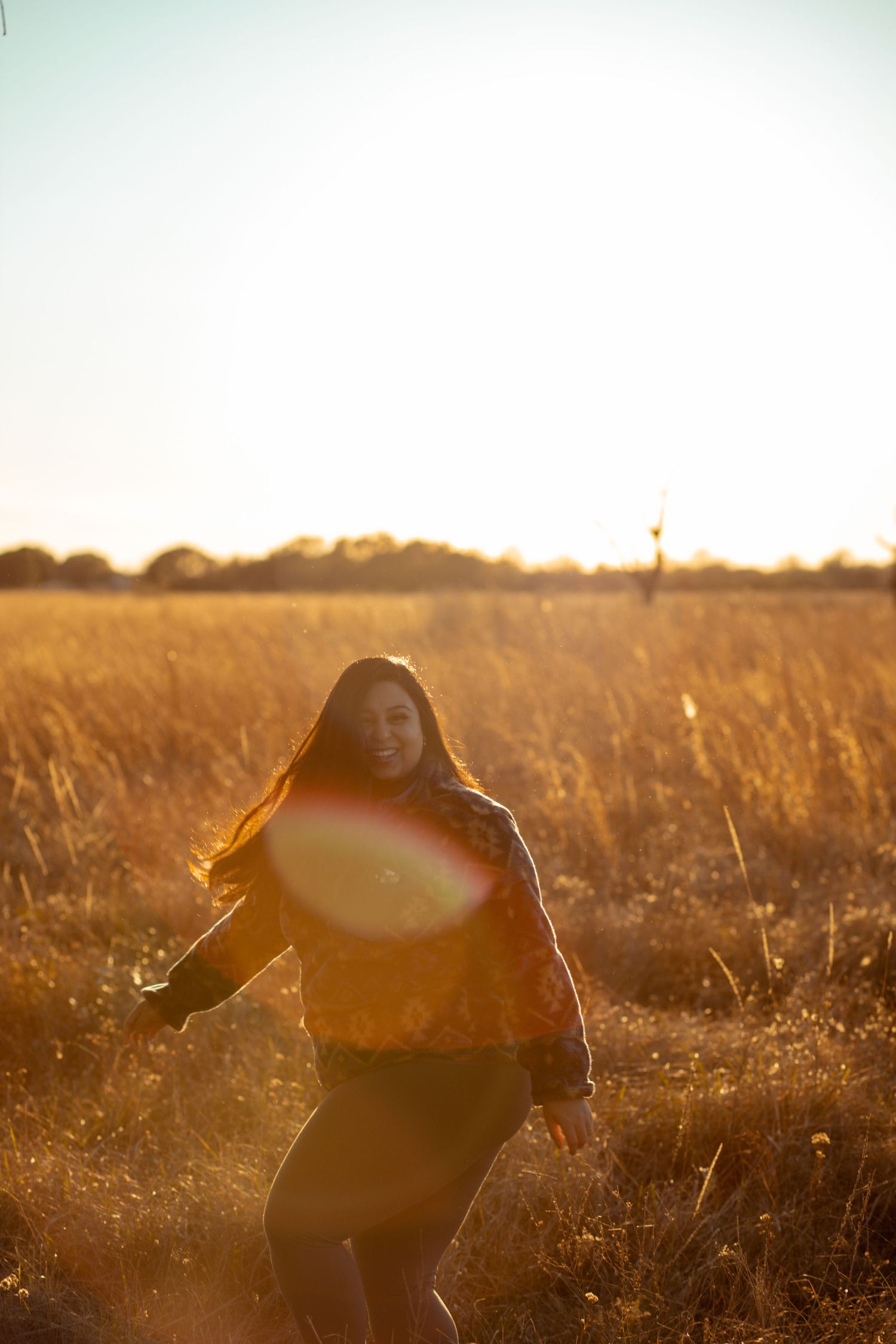 sunny person in field twirling