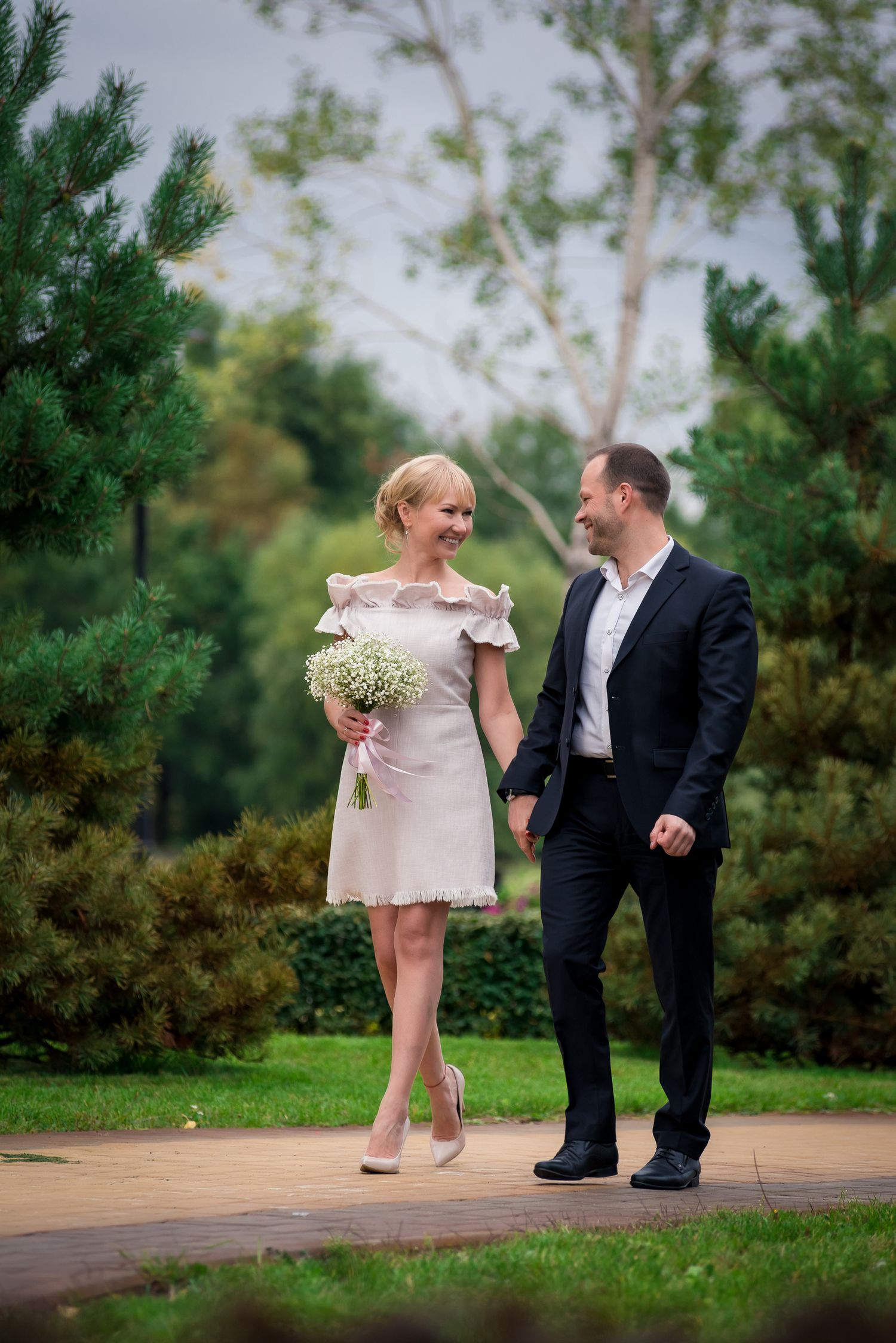 Romantic outdoor couple photoshoot in a garden setting with natural greenery.