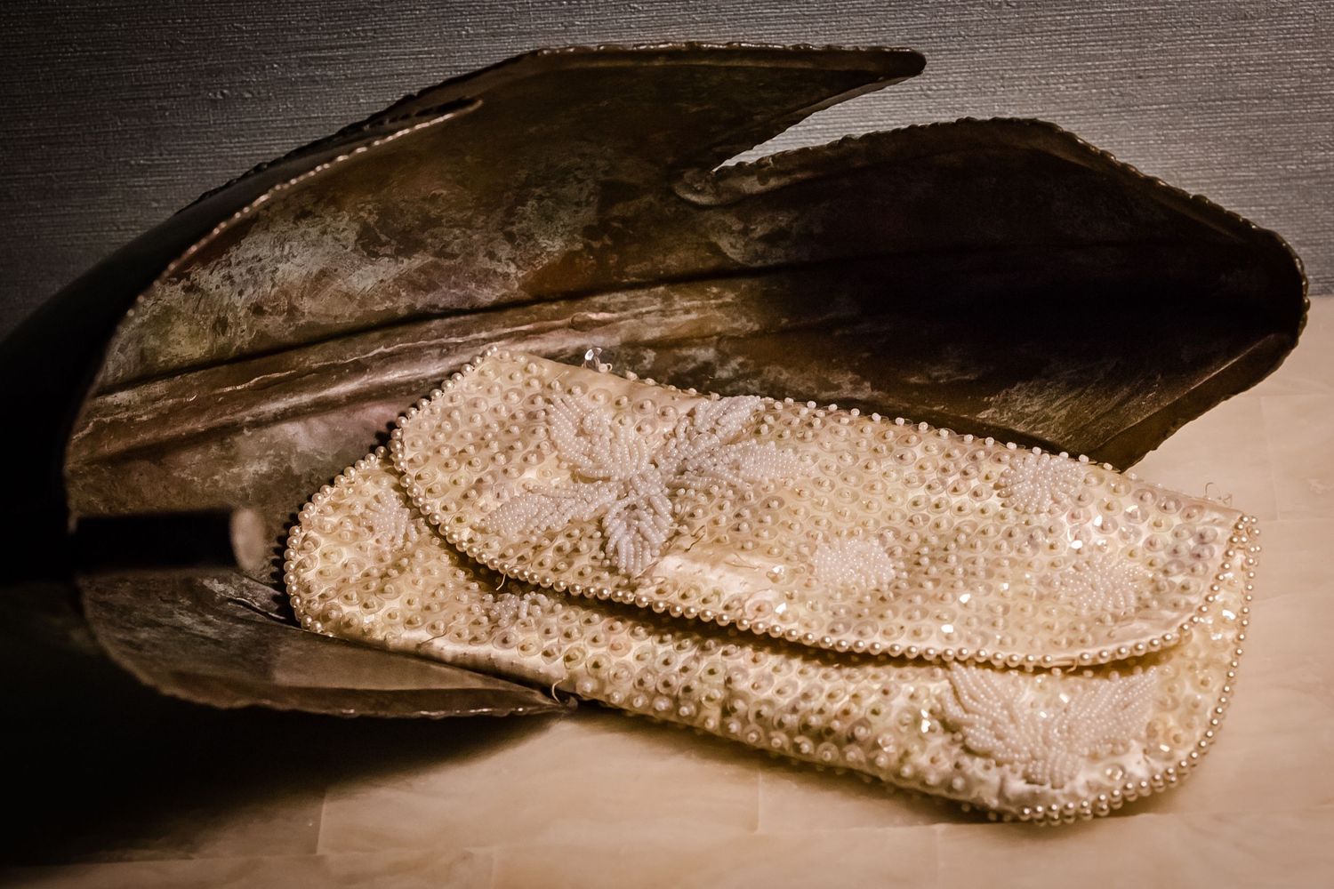Elegant beaded bridal accessories photographed with dramatic lighting on dark background.