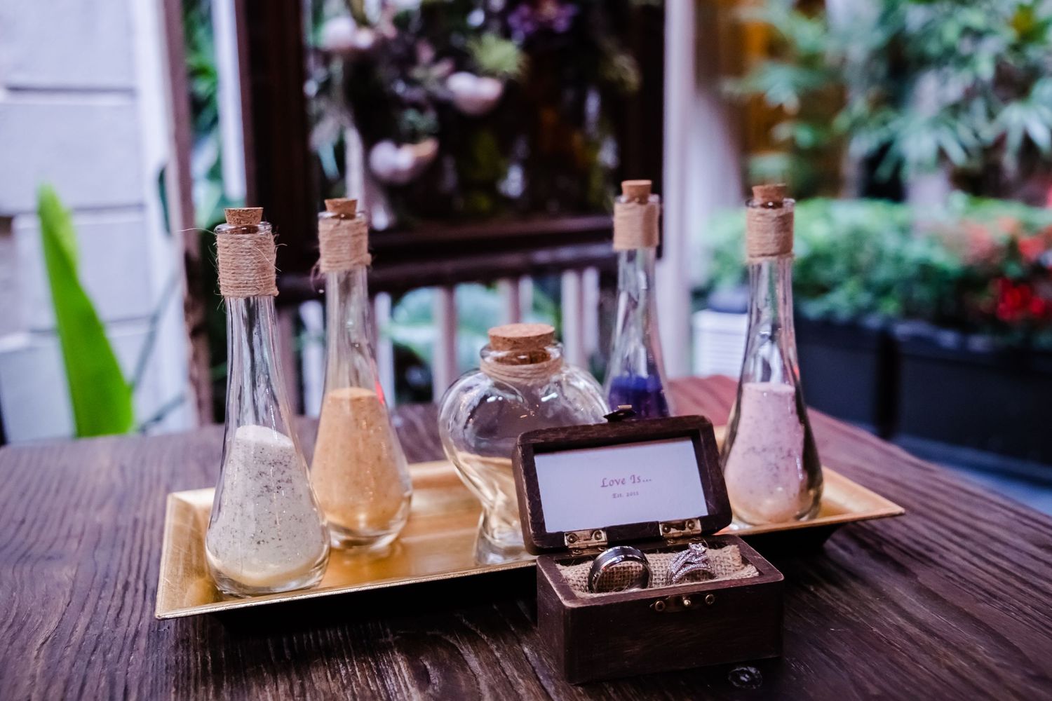 Elegant table settings with wine glasses and floral arrangements at an outdoor restaurant.