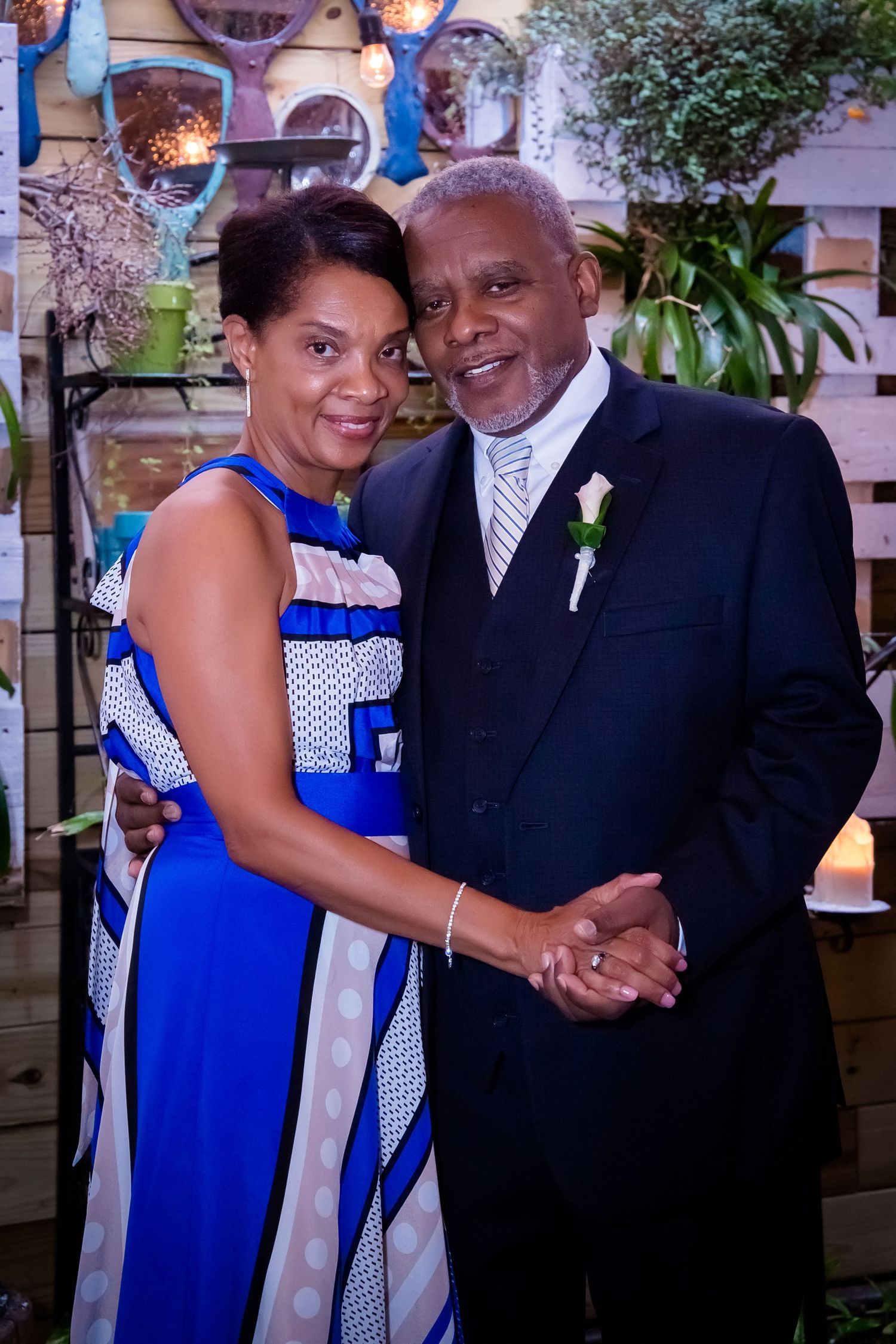 A couple enjoying a formal event in elegant blue and black attire.