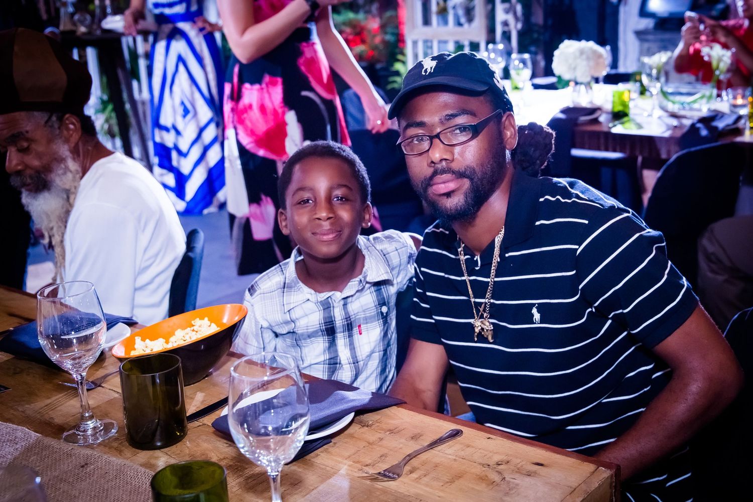 Friends gathered around a dining table enjoying conversation at an evening event.