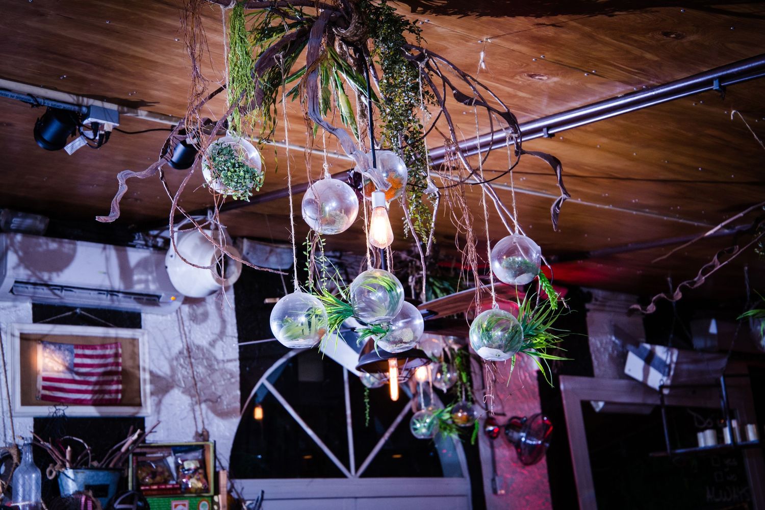 String lights and hanging glass orb decorations create romantic ambiance at wedding venue.