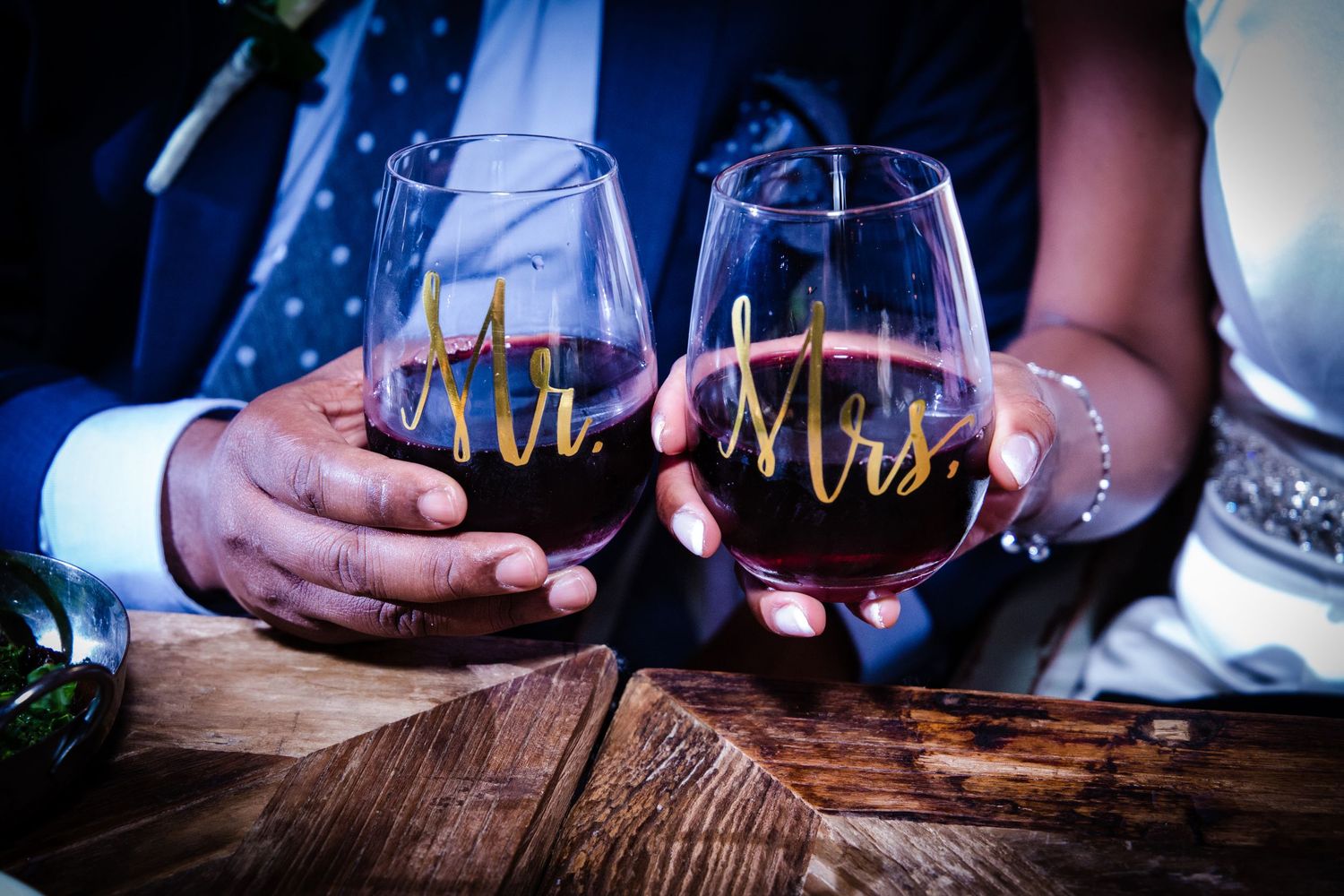 Wedding reception table details with wine glasses and Mr & Mrs decor.