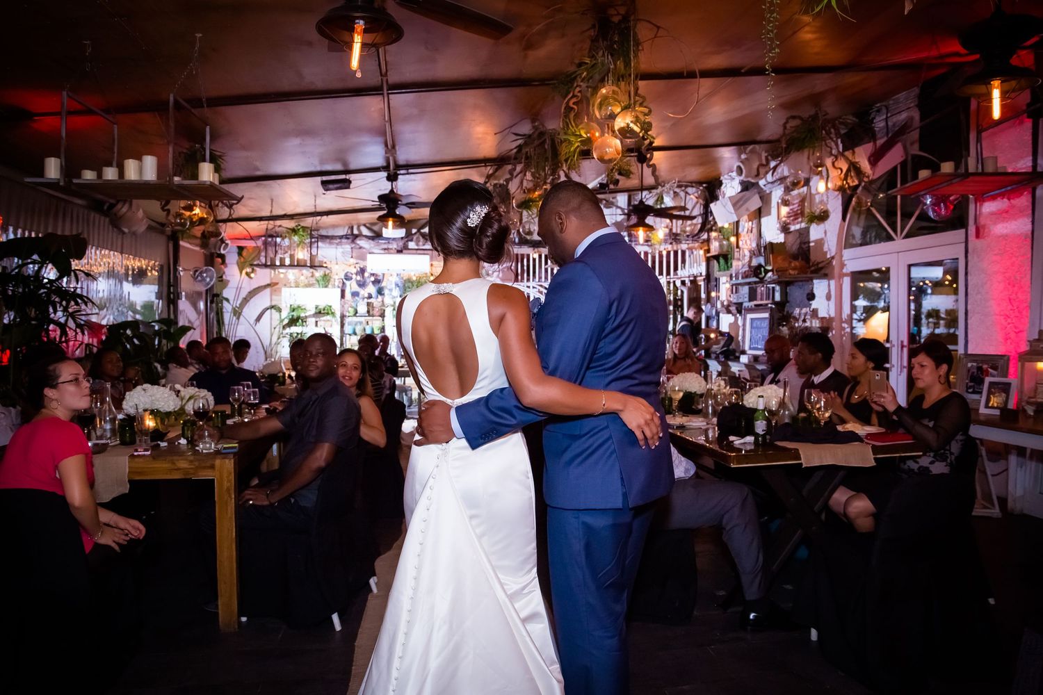 Wide view of a rustic wedding reception venue with ambient lighting and decorations.