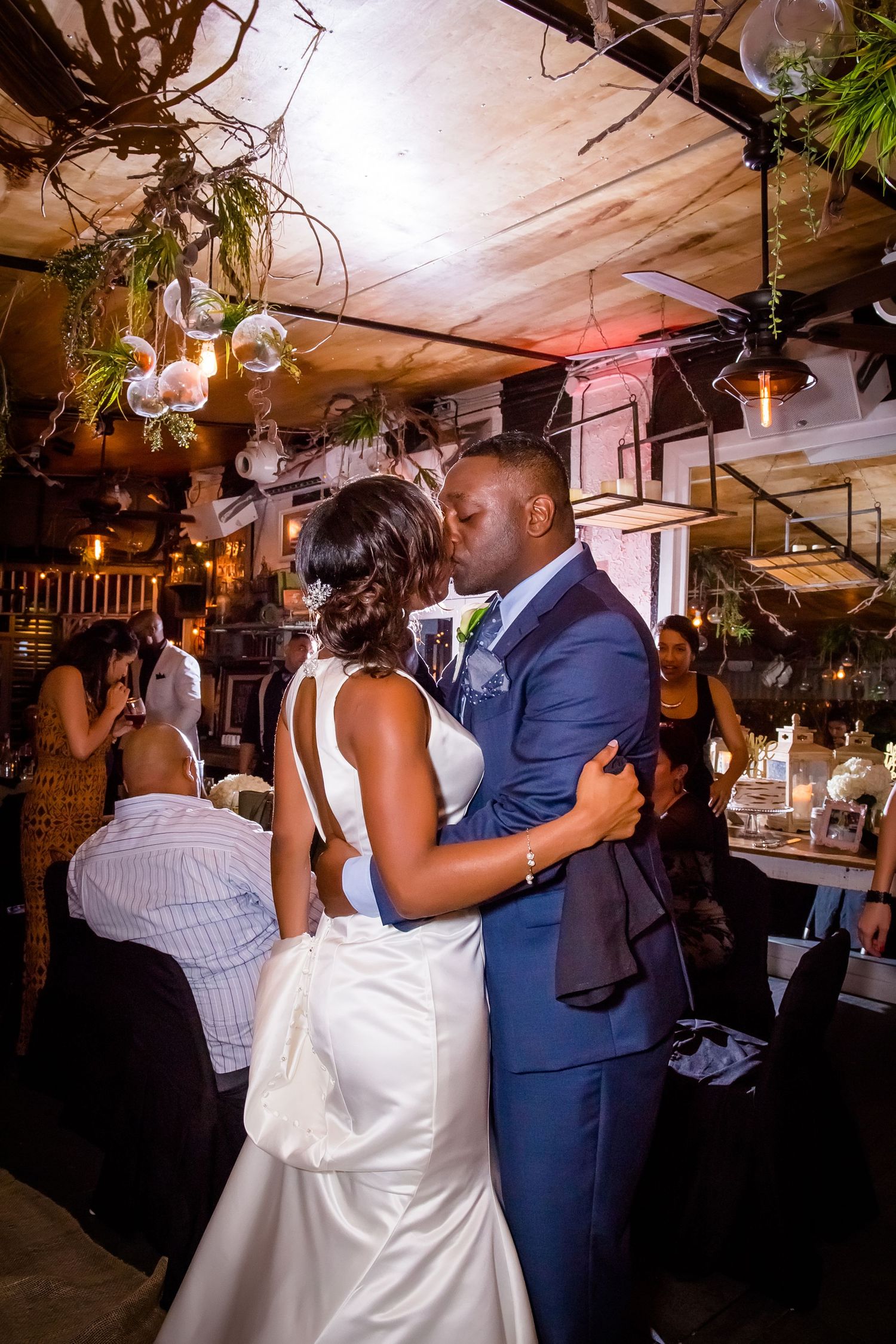 Wedding couple dancing together surrounded by guests at their reception venue.