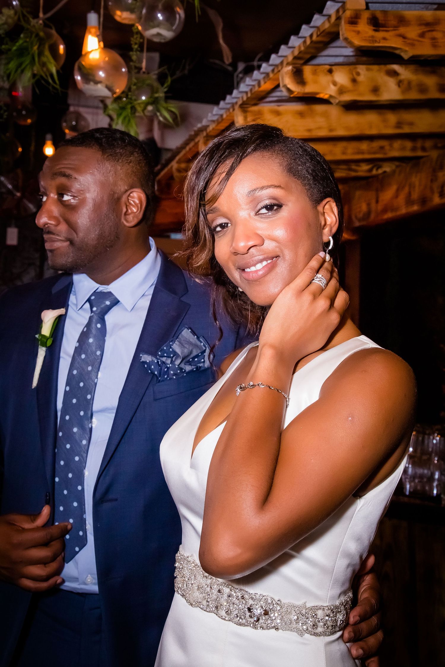 Couple sharing emotional moments during their wedding reception in a rustic-themed venue.