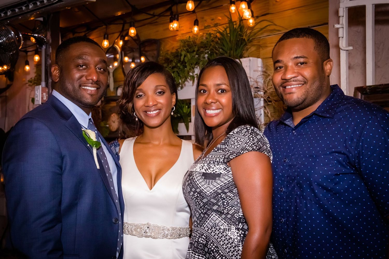 Wedding celebration with guests in formal attire gathered at an elegantly lit indoor venue.