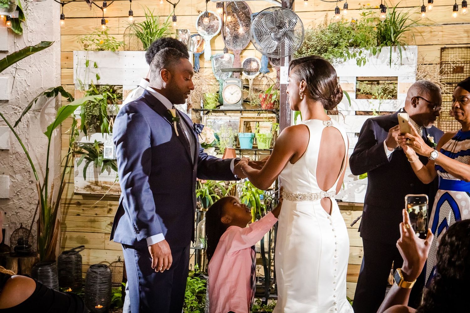 Couple shares a joyful moment during their wedding ceremony in a rustic venue.