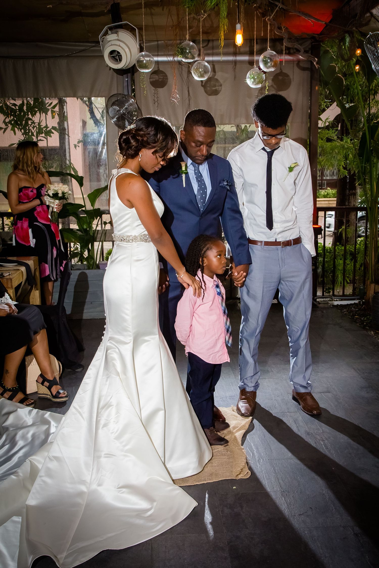Wedding couple dancing together in an elegant venue with guests looking on.