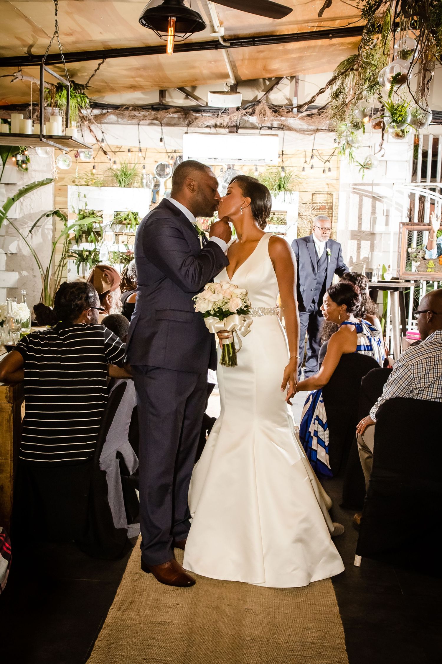 Wedding reception dance floor filled with couples dancing under string lights.