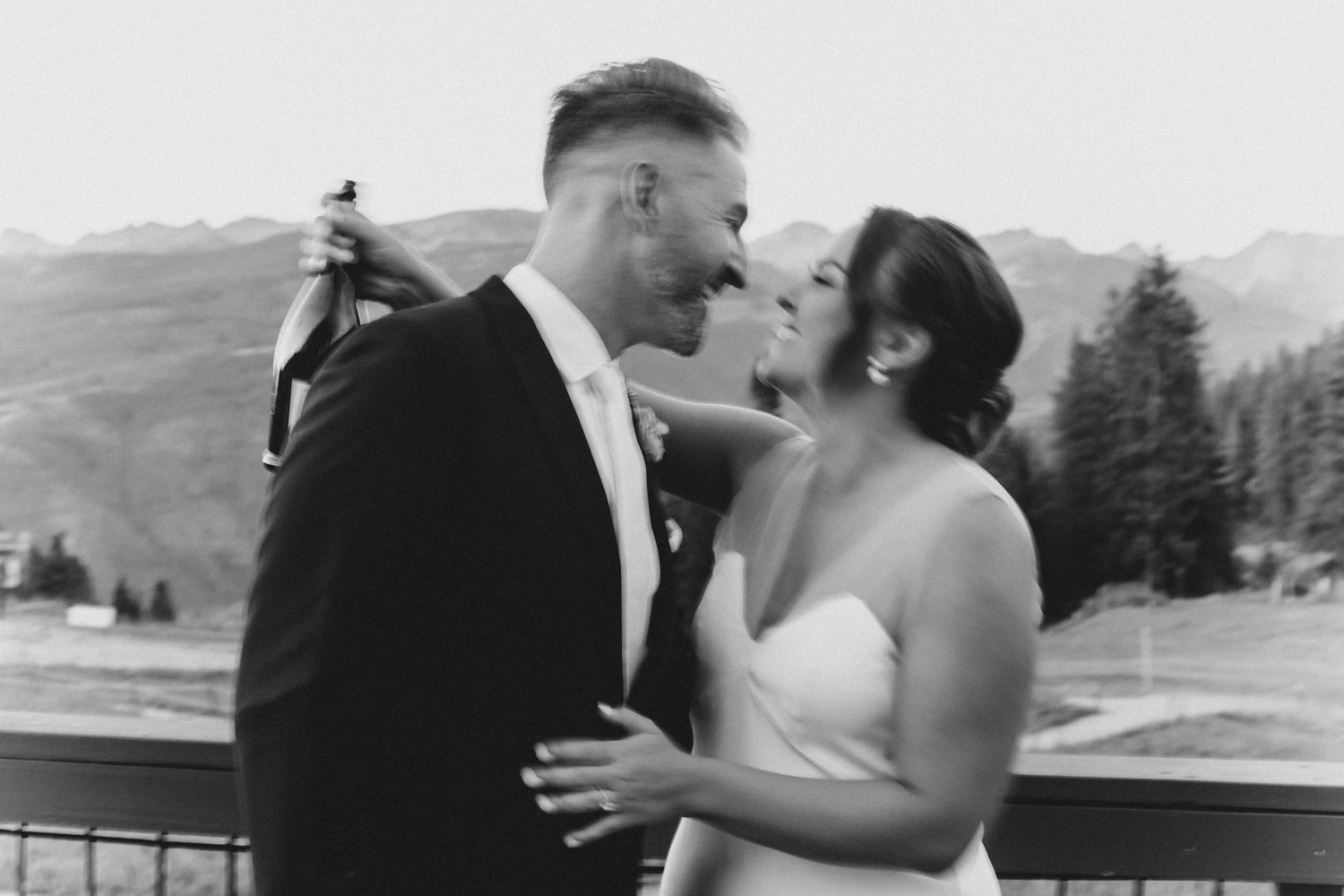 A couple shares intimate moments during their wedding photoshoot against a mountain landscape.