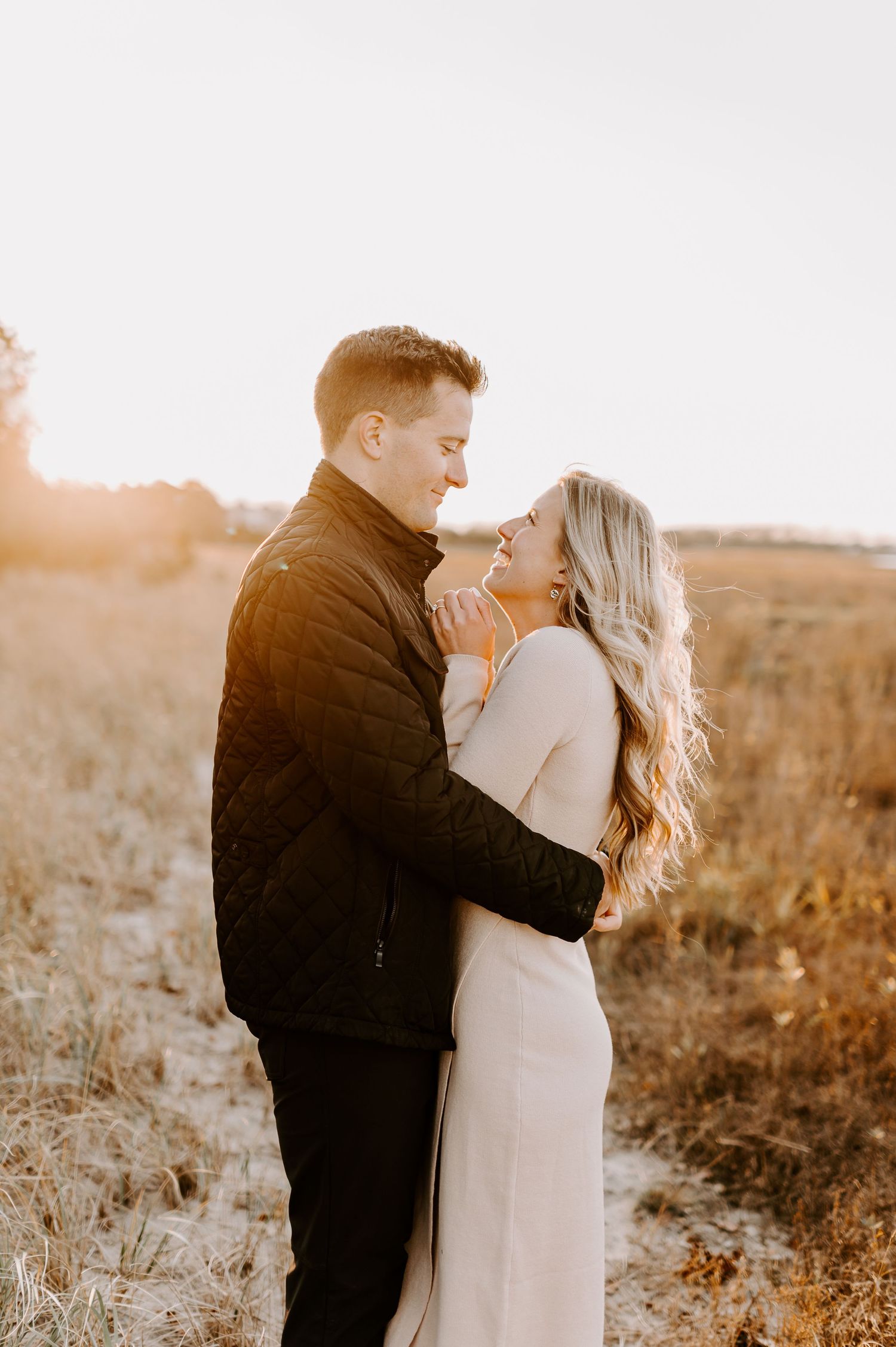 Golden hour portrait of couple sharing intimate moment in autumn field.