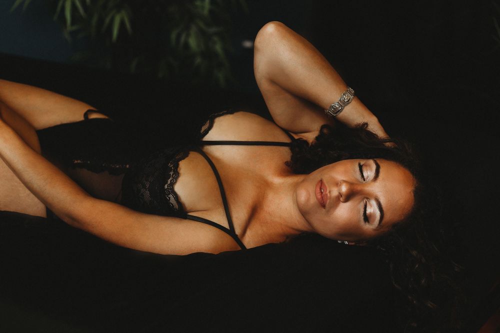Intimate portrait with black lingerie against dark background.