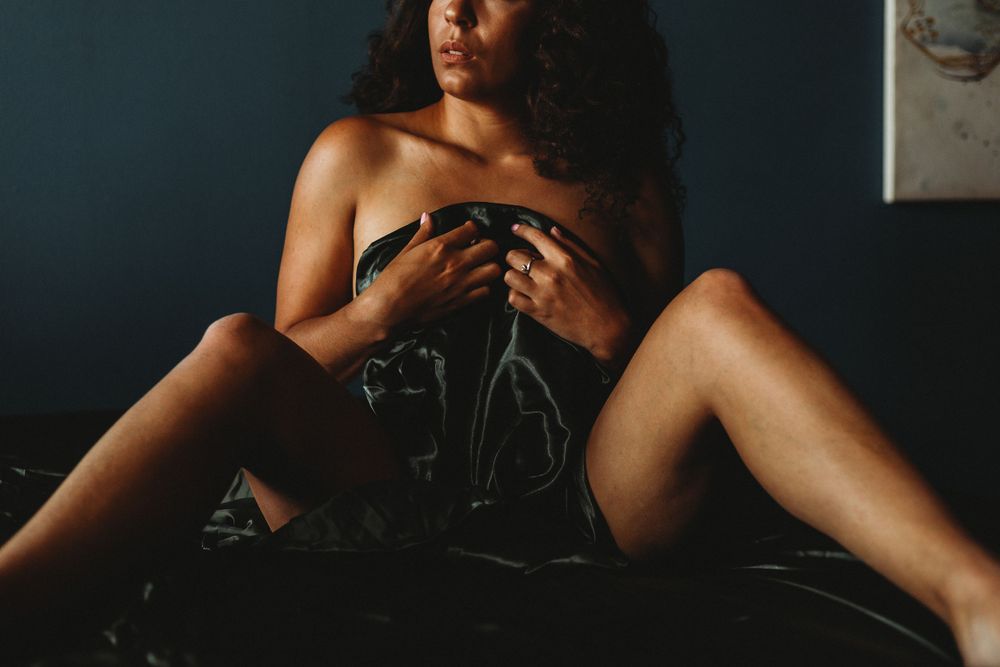 Intimate portrait with dark fabric in dim lighting.