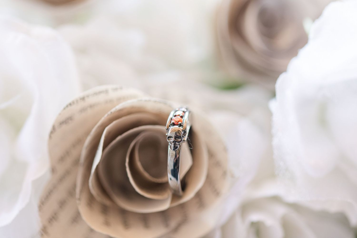 Delicate beige and white roses with diamond rings nestled among the petals.