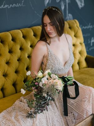 Wearing a crystal crown, beaded lace gown and a large bouquet, the young LBGTQ bride wait for her wedding ceremony.