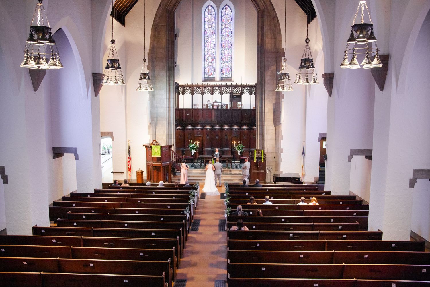 Interior of traditional church with gothic arches and wooden pews ready for wedding ceremony.