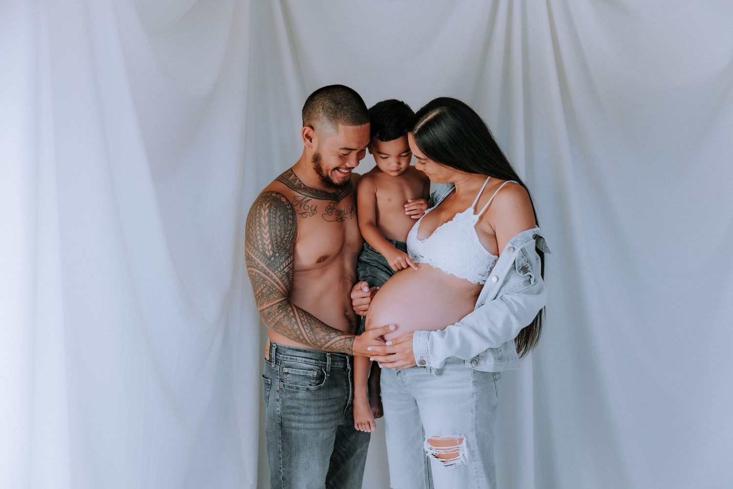An intimate maternity photo shoot against a white backdrop.