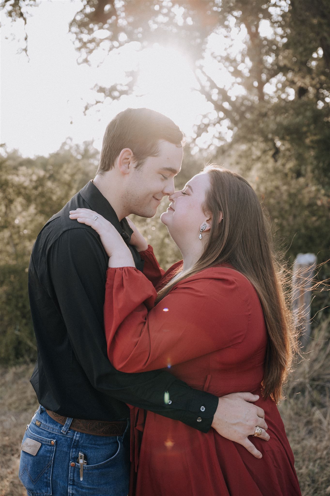 A romantic moment captured between a couple in complementary outfits during golden hour.