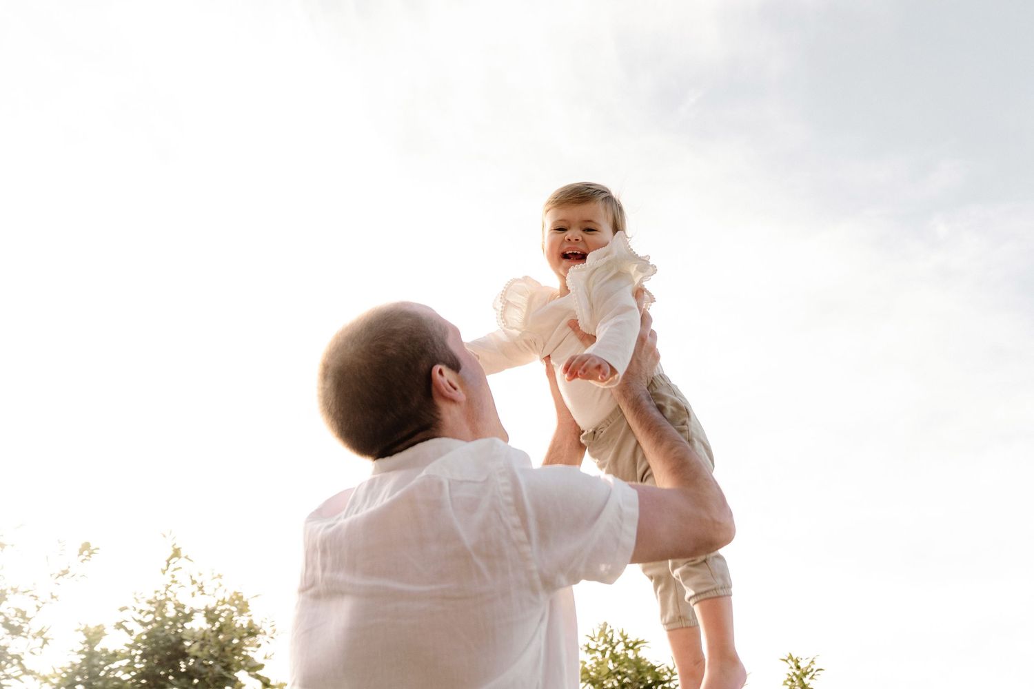 Baby going up in the air with dad.  Relaxed Family Photographer Auckland