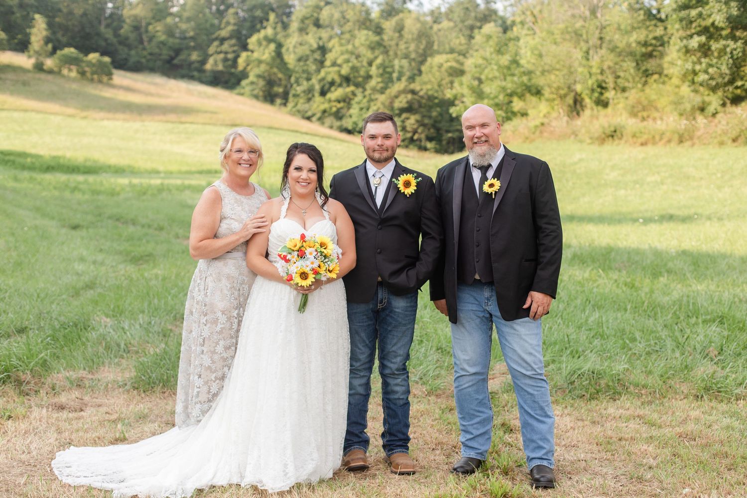 Wedding party posing together outdoors with sunflowers and formal attire.