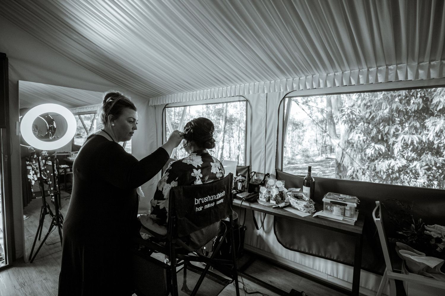 Black and white photo of preparation scene in light-filled room with professional equipment.