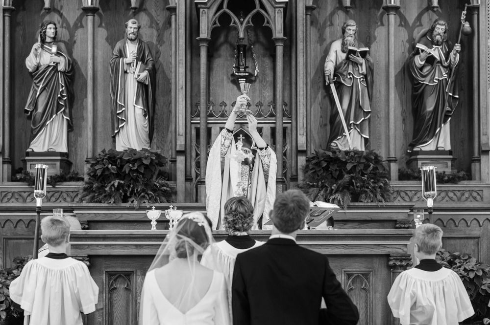 Priest elevates the Host during wedding mass at St. Francis Xavier in Stillwater, Oklahoma.