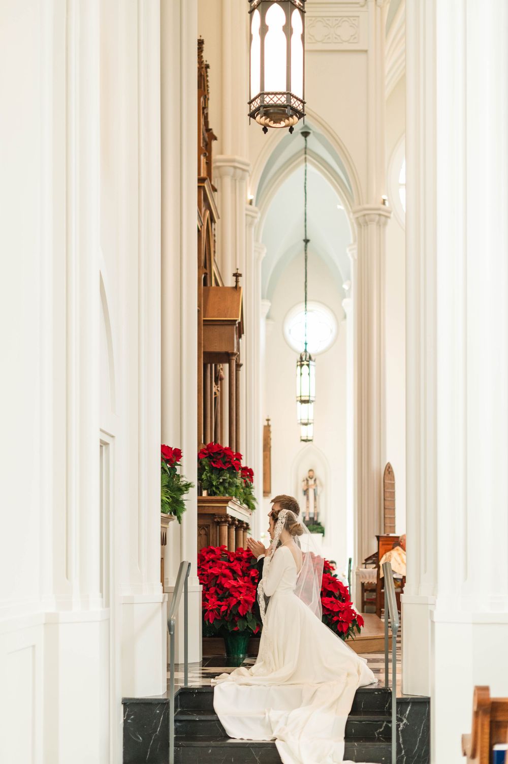 Husband and wife praying during their wedding mass at St. Francis Xavier in Stillwater, Oklahoma.