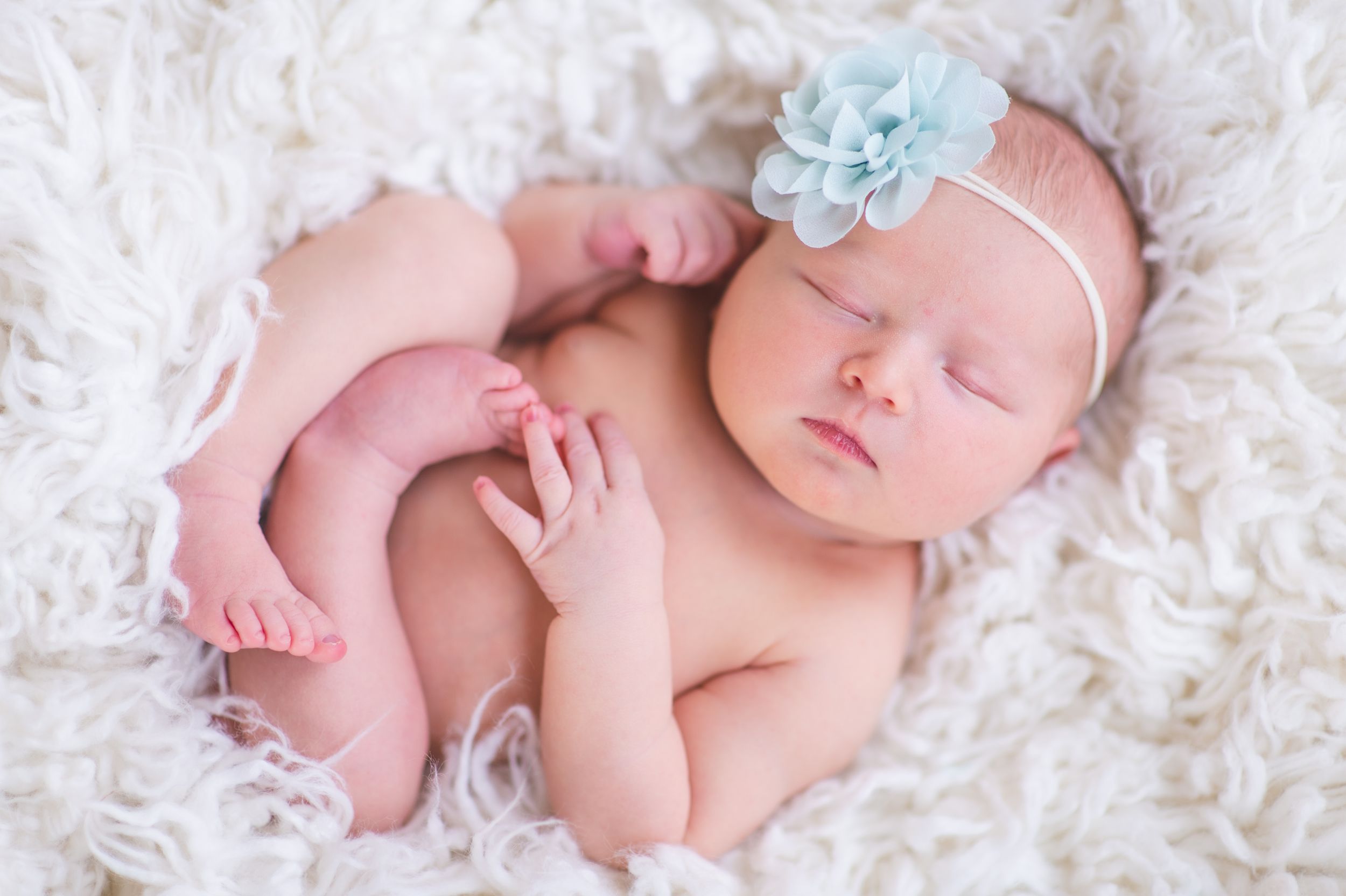 Newborn baby girl custom headband soft focus sweet baby little bundle of smile captured sleepy baby Alabama Fairhope natural light studio