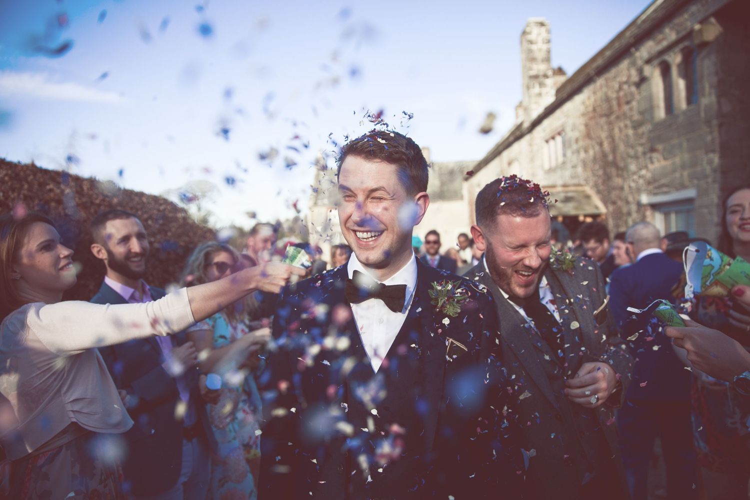 Same sex wedding smiling flower petal confetti shot
