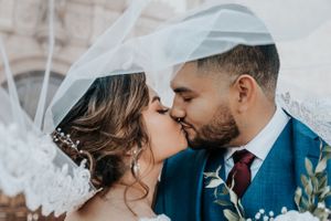 Tucson wedding photo of a bride and groom kissing under the veil, capturing a romantic and intimate moment on their special day.