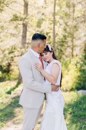 Tucson couples photo of a man and woman sharing a kiss in a forest setting with soft, natural light.