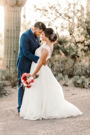 Romantic Tucson wedding photo of a groom lifting his bride for a kiss in the desert at golden hour.