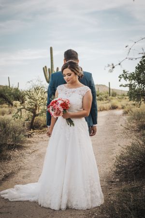 Tucson desert bridal portrait with bride holding a colorful bouquet among saguaros.