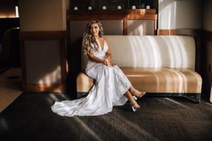 Tucson bridal portrait of a bride sitting elegantly on a hotel lobby couch in her wedding gown.