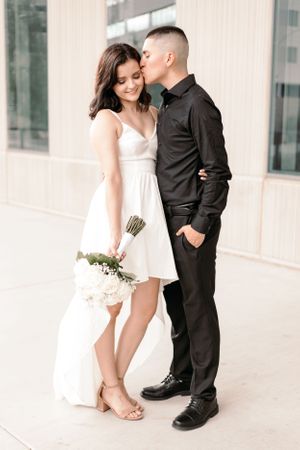 Tucson wedding portrait of a bride and groom walking hand in hand outside a modern architectural building.