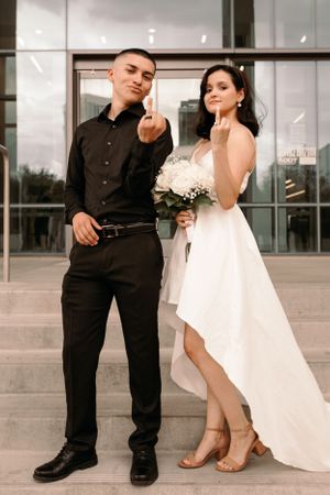 Tucson wedding portrait of a bride and groom walking together outside a sleek modern architectural building.