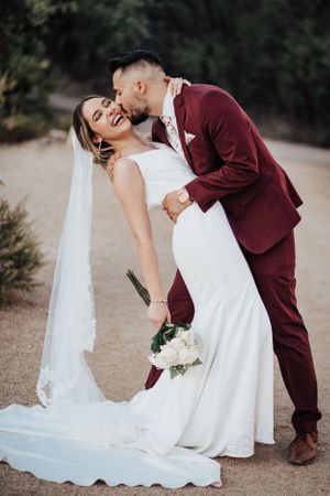 Tucson wedding photographer captures groom dipping and kissing his bride in the desert with romantic, natural light.